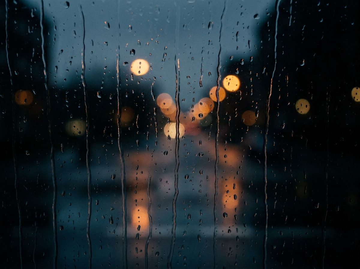 Rain running down a dark window at first light